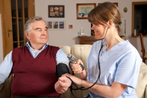 Pflegekraft misst Blutdruck bei Senior